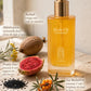 A bottle of Cleo VII Body Oil with golden yellow liquid and a gold pump, styled on a textured stone surface with natural ingredients including a sliced prickly pear, black seeds, and sea buckthorn berries. Text callouts describe the ingredients.